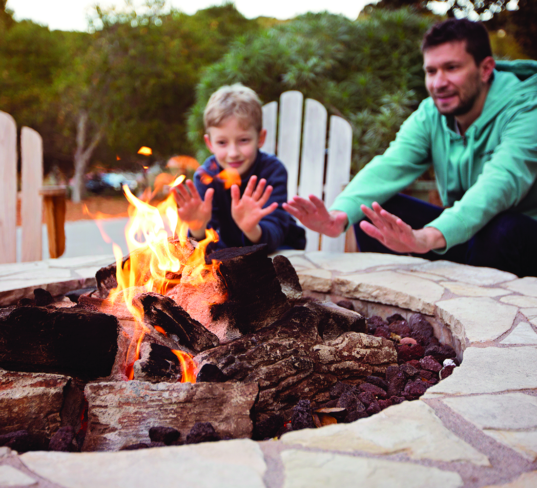 father and son warming up by the fire