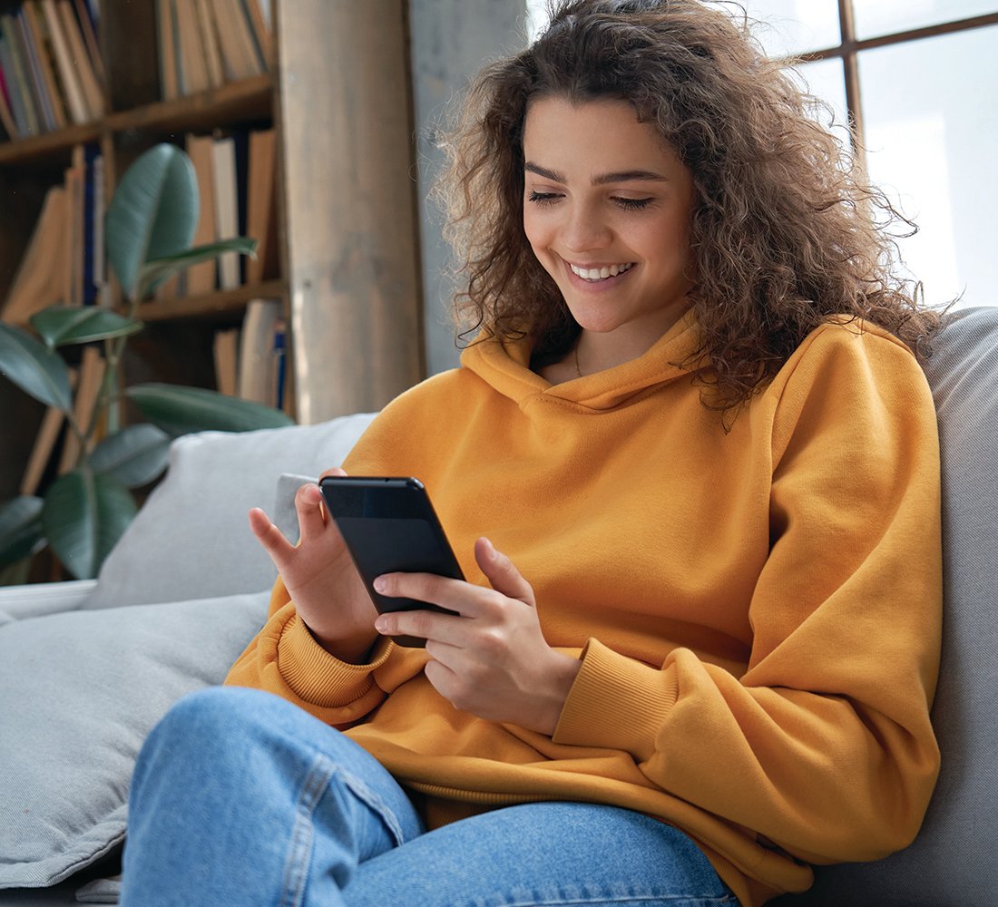 woman on couch banking on phone