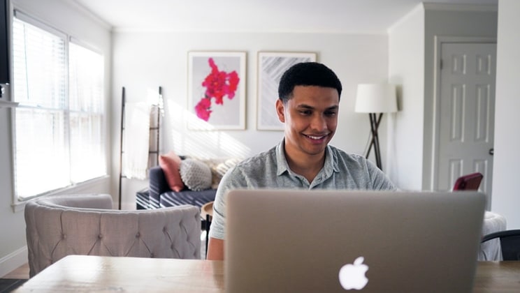 man smiling at laptop