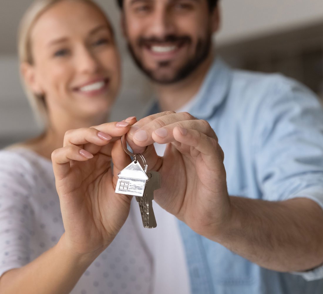 husband and wife holding key to house