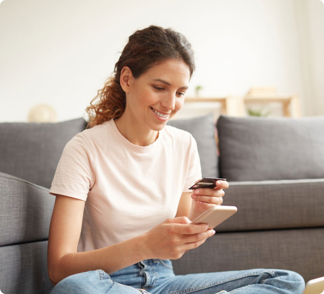 woman smiling with phone and credit card