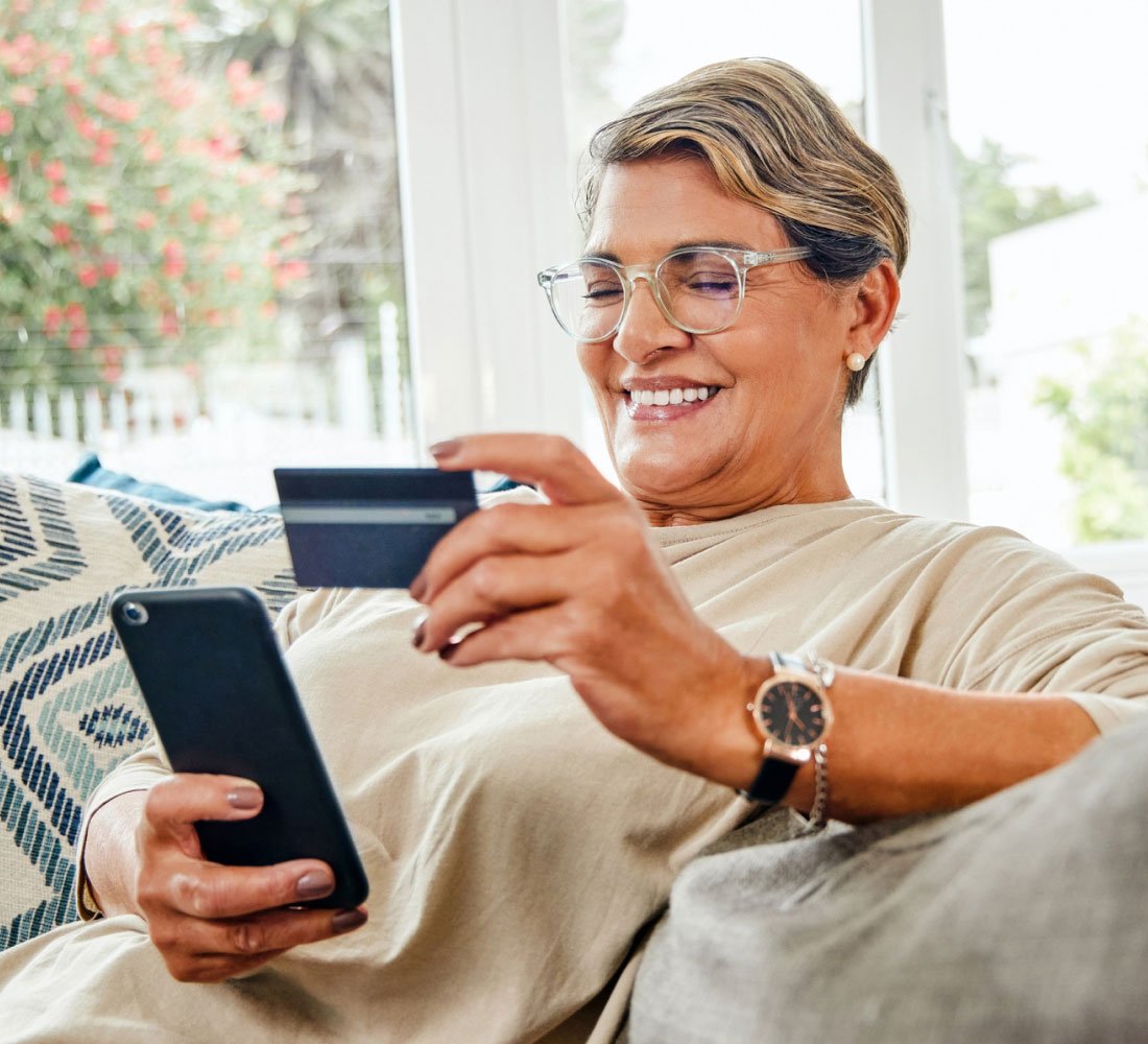 woman sitting on couch smiling with card