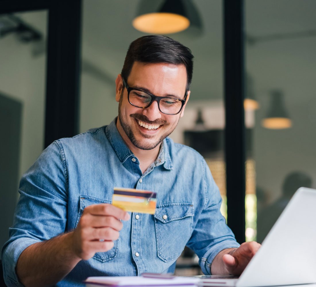man smiling with credit card