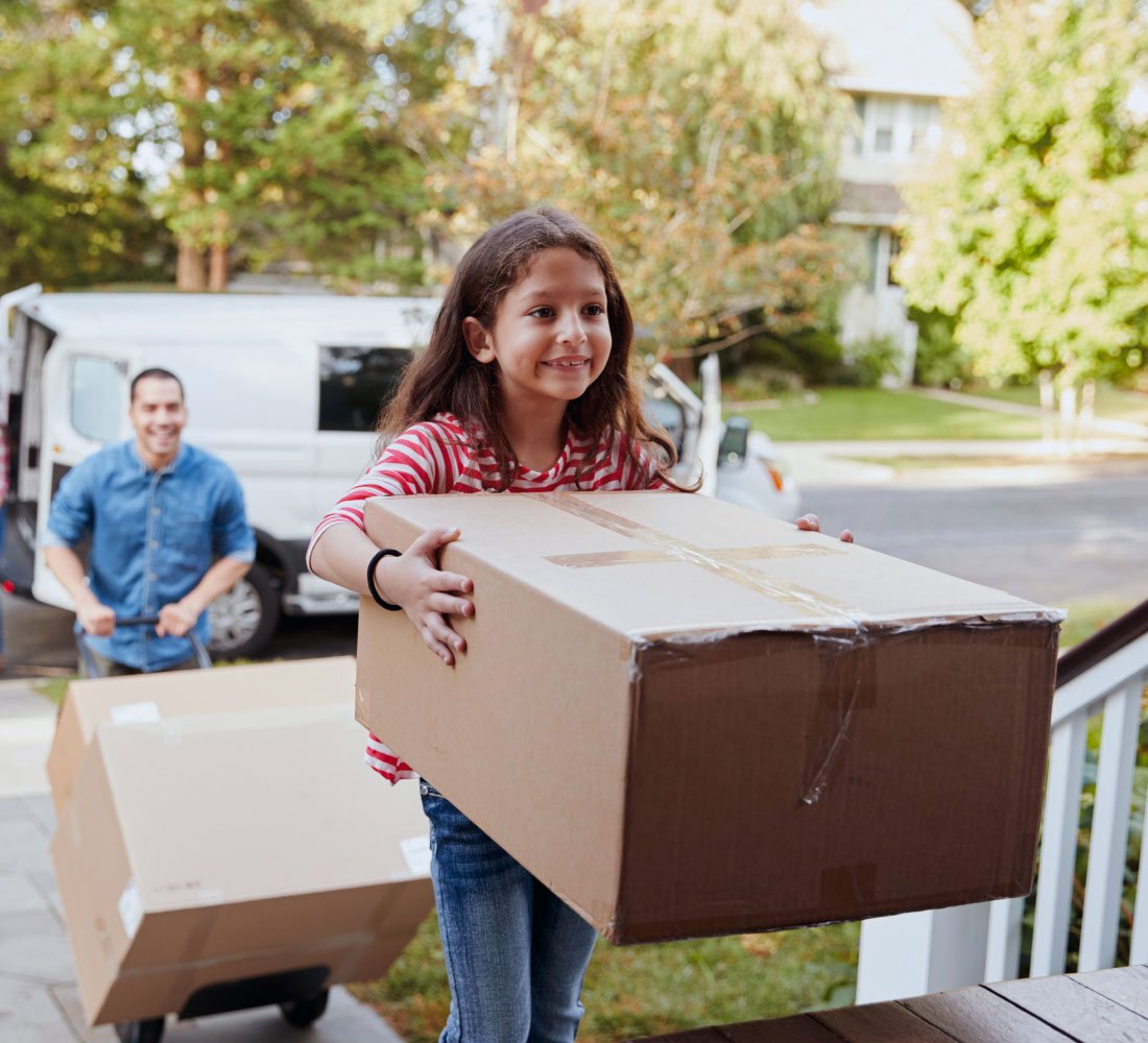 little girl carrying box