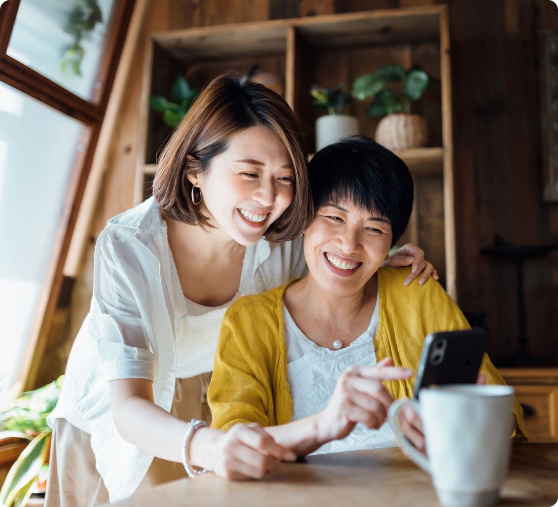 mother and daughter smiling at phone