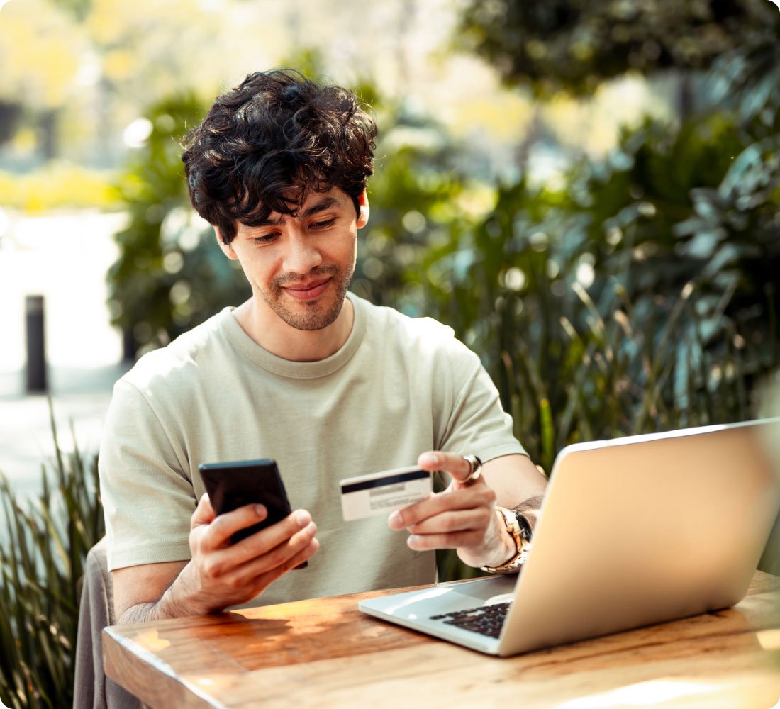 man looking at phone with debit card