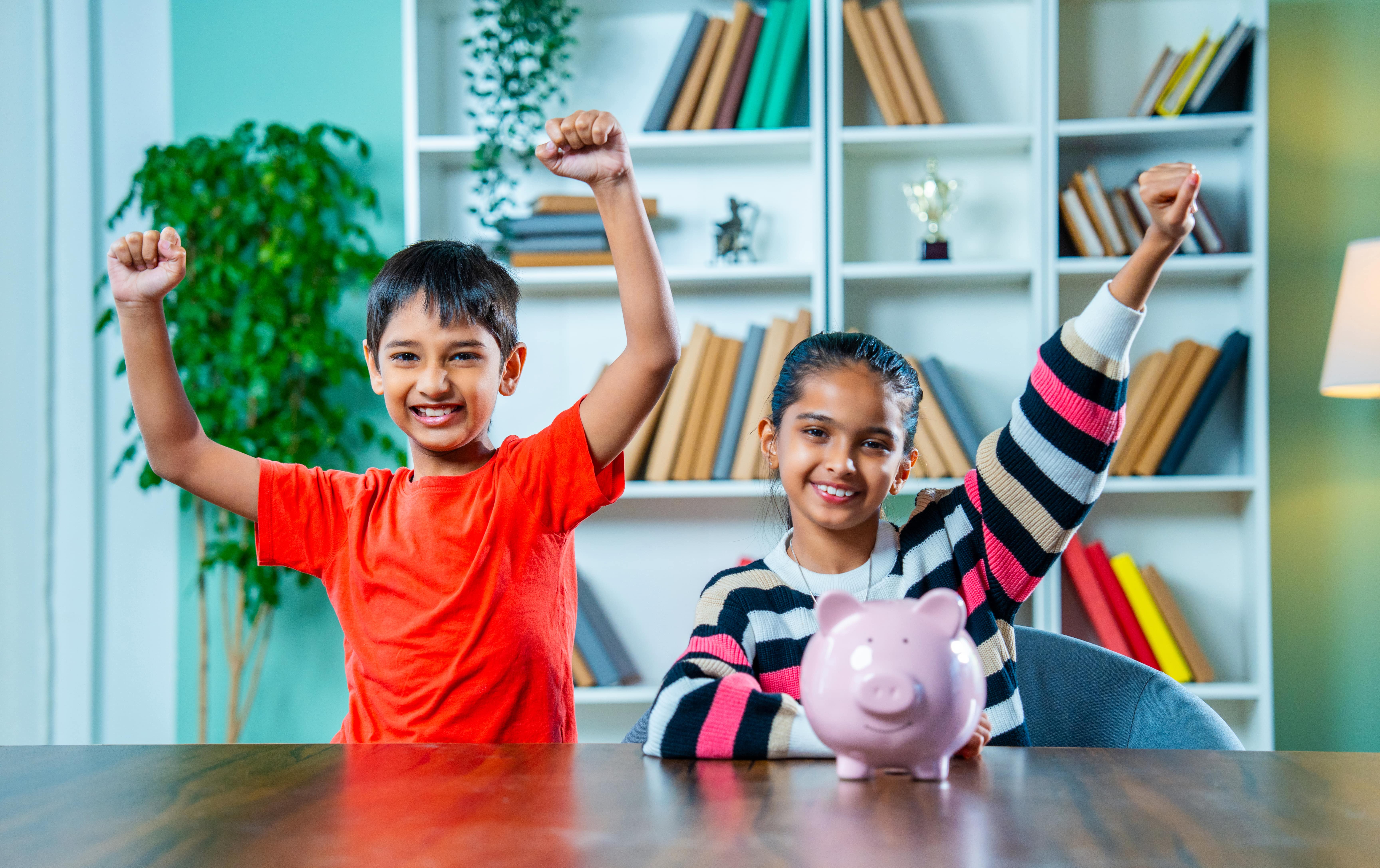 two kids excited about the savings in the piggy bank