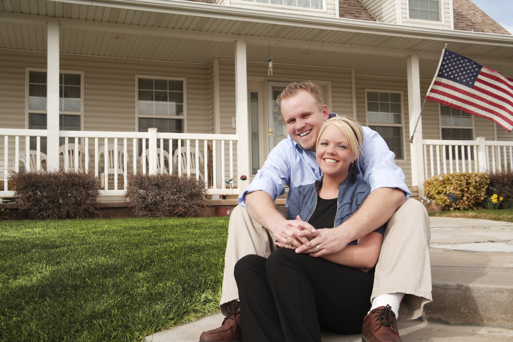 happy couple in front of house