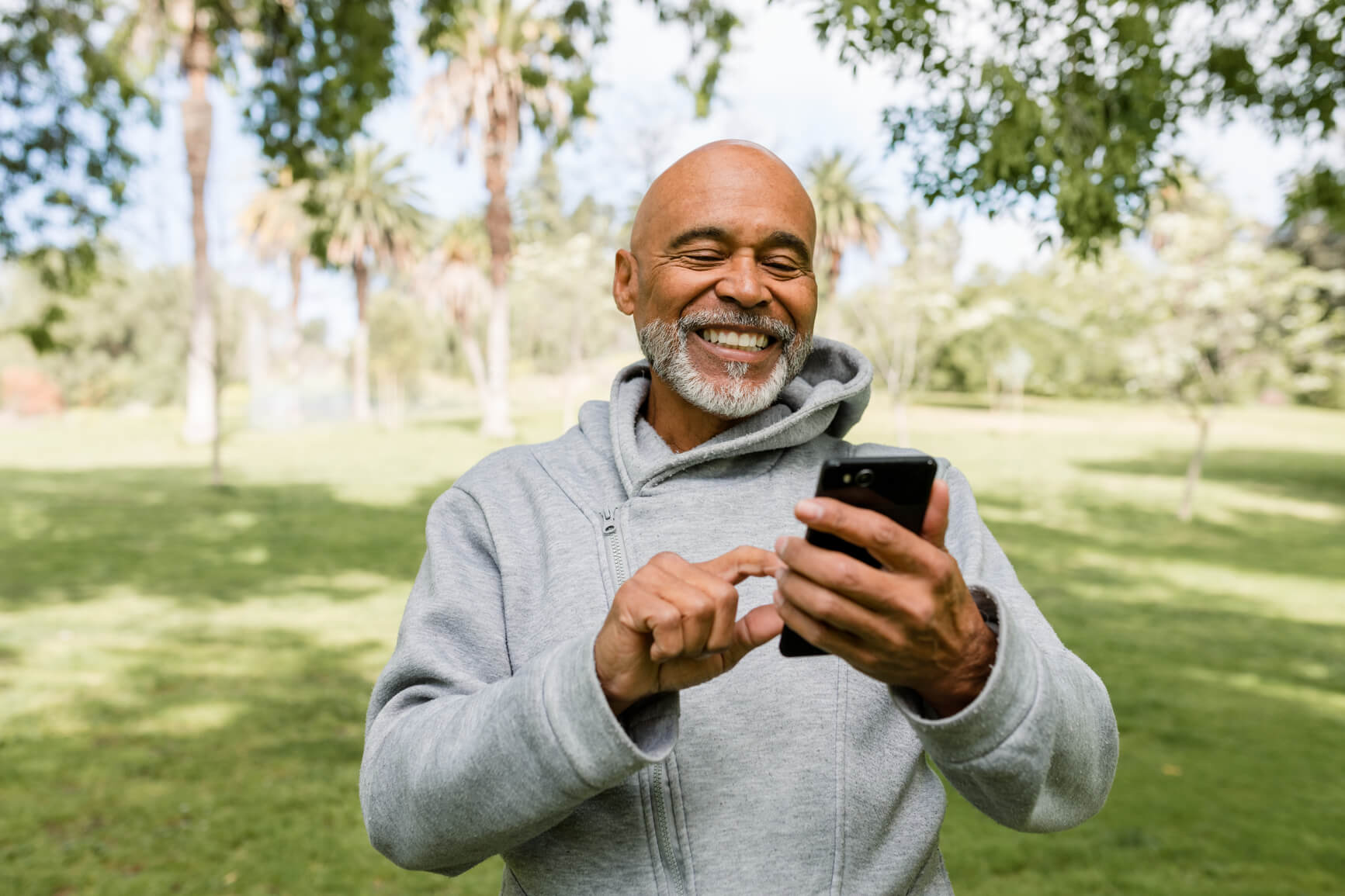 A man smiling while using Bellwether's Credit Union mobile banking app