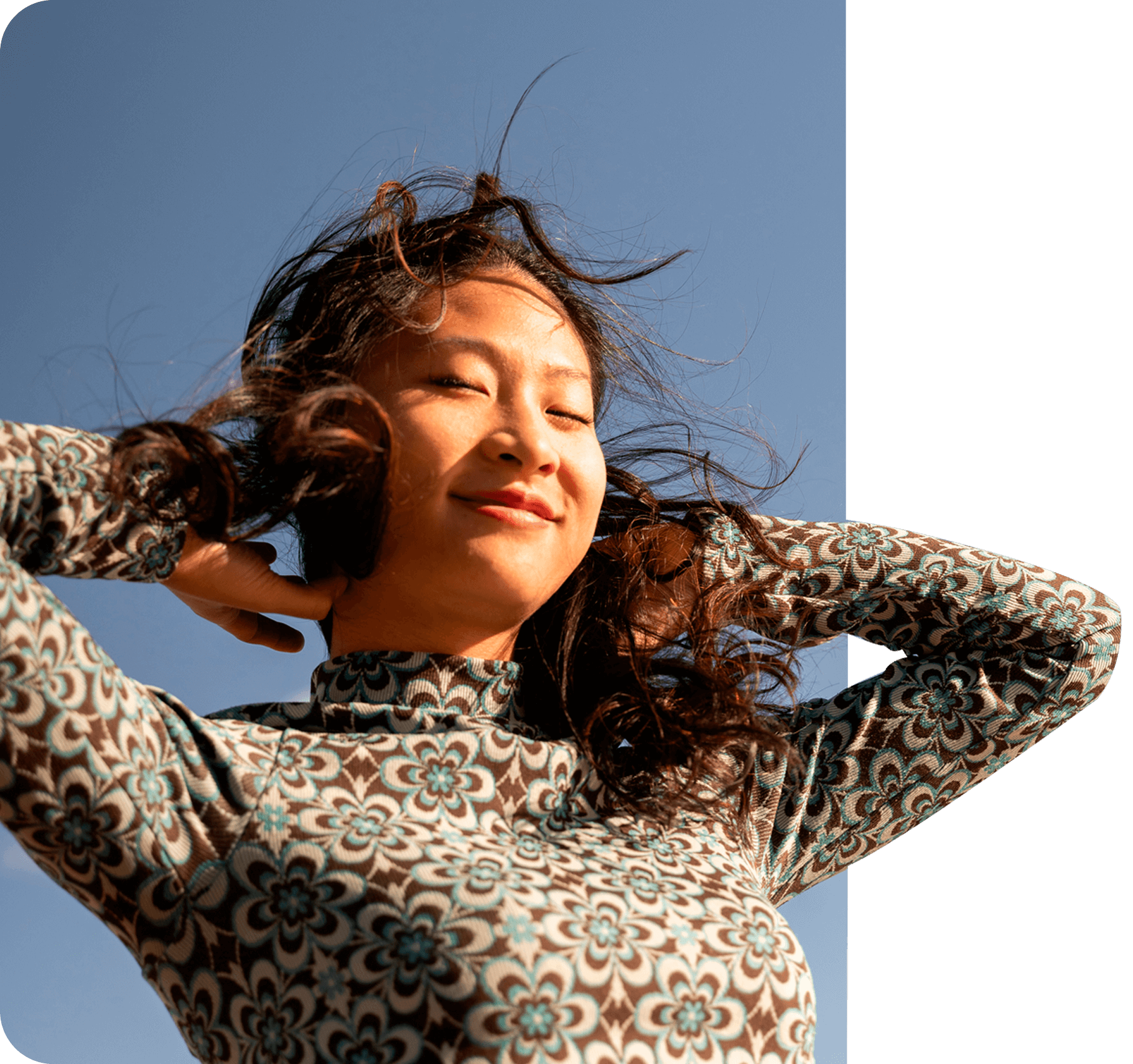 A woman with her hair floating in the breeze, with a look of contentment on her face A woman with her hair floating in the breeze, with a look of contentment on her face